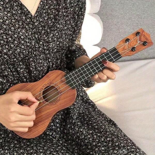 Een mini-gitaar van 35 centimeter, geschikt voor het bespelen van eenvoudige instrumenten, met een plectrum, die een ukelele nabootst, ideaal voor beginners. Het is een gitaarpuzzel en muziekinstrumentenset.