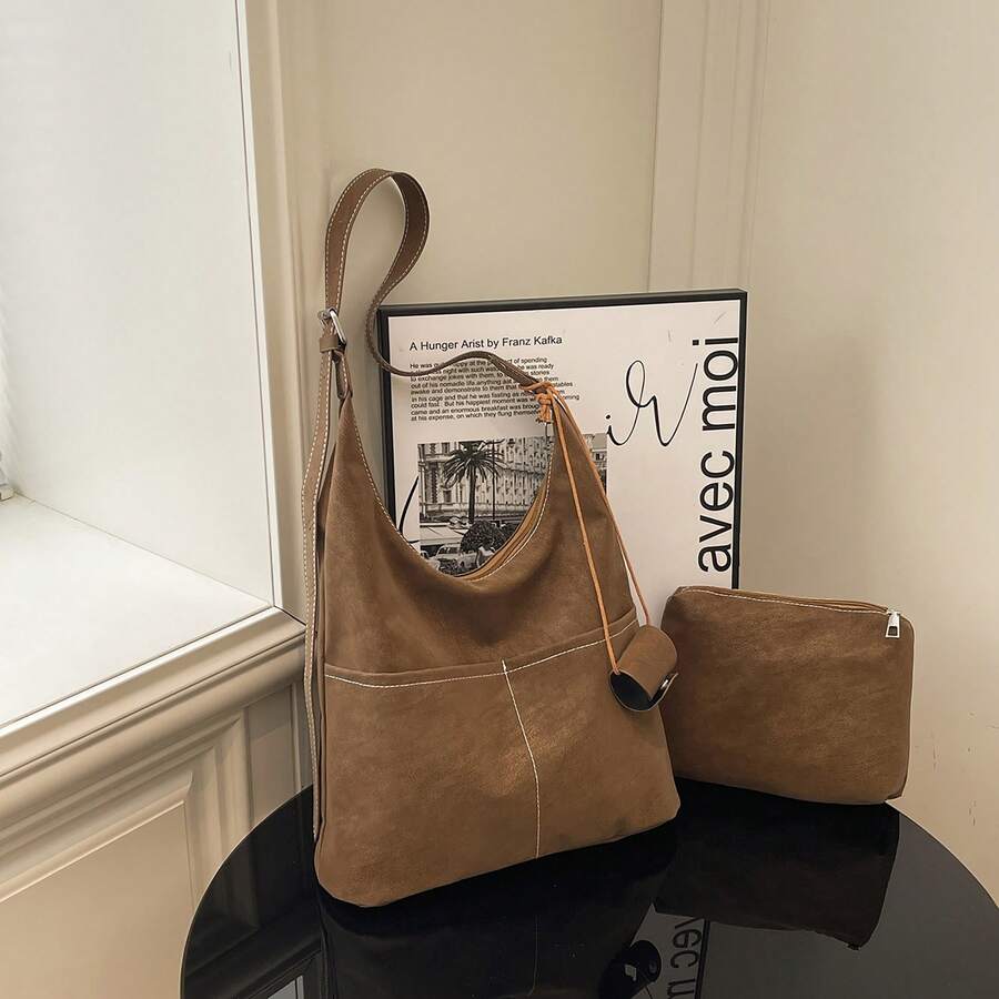 这款两件套包括一个大容量天鹅绒手提包和一个配套手拿包，展现出时尚百搭的风格，非常适合日常通勤。