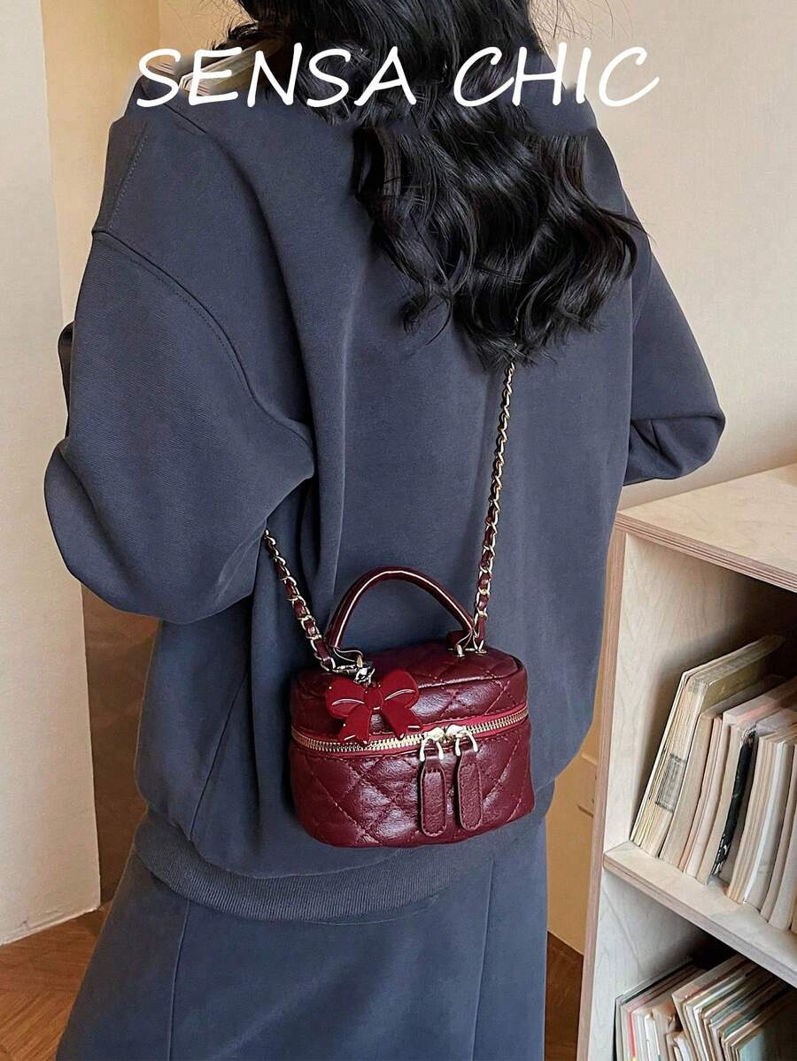 Đây là một chiếc túi xách nữ màu đỏ tía chất lượng cao, có thiết kế họa tiết hình thoi, điểm nhấn là chiếc nơ đỏ, một quai xách phía trên và dây đeo bằng kim loại có thể điều chỉnh. Bên trong có thể chứa những vật dụng cần thiết hàng ngày như son môi, chìa khóa và mỹ phẩm. Rất phù hợp để đi làm, đi chơi, mua sắm, hẹn hò và sử dụng hàng ngày. - Xem 1