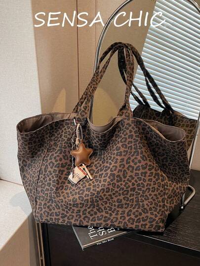 Dit is een ruime draagtas met binnenvoering, uitgevoerd in een bruine kleur. De buitenkant is voorzien van een koffiekophaak en een luipaardprint, met twee handvatten om de tas over de schouder of in de hand te dragen. Binnenin passen dagelijkse benodigdheden zoals lippenstift, sleutels, een waterfles, een paraplu en cosmetica. Geschikt voor vrouwen die de tas gebruiken op kantoor, tijdens uitstapjes, om te winkelen, op zakenreis of op vakantie.