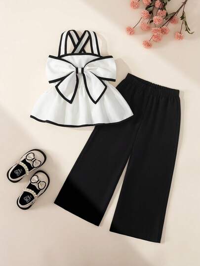 BASUSARRI Bộ đồ thể thao sành điệu cho bé gái, gồm áo crop top màu trắng phối tương phản với dây đeo bản rộng và nơ lớn, kết hợp quần lửng ống đứng, thời trang đa năng.