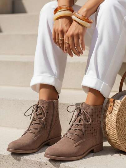 Dames enkellaarsjes met opengewerkt vetersluiting, gemaakt van imitatie suède, met een 14 cm hoge schacht versierd met een opengewerkt patroon, een lage hak van 2,5 cm, een ritssluiting aan de zijkant en vetersluiting, een gesloten neus en een stevige plastic zool.