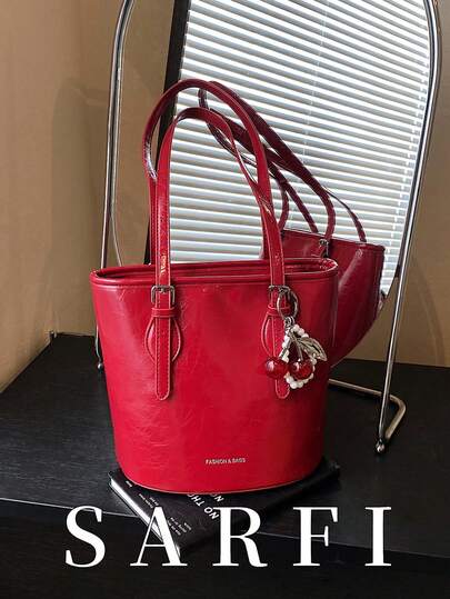 这款纯红色女士单肩包配有樱桃挂饰，樱桃装饰增添了一丝时尚简约之美。它容量大，可容纳多件物品，并采用拉链封口。这是一款实用且多功能的单肩包。这款手提包采用耐用防水的PU材质制成，适合作为礼物送给朋友，也适合购物、约会、通勤上班、拍照、商务旅行和日常出行。