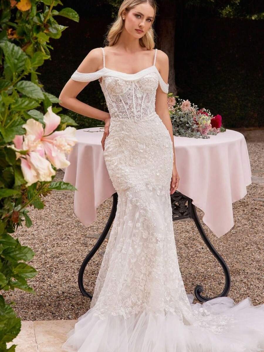 Sheer Lace Mermaid Wedding Dress Off Shoulder Illusion Bridal Gown 2026 Lace Fitted Bridal Dress For Bride, Elegant Off Shoulder Illusion Neckline Frames Shoulders And Collarbone While Creating A Refined Structured Upper Silhouette, Full Lace Coverage Bodice With Intricate Floral Lace Pattern Shapes The Waist And Enhances Natural Curves With Detailed Craftsmanship, Figure Contouring Mermaid Silhouette Closely Follows Waist Hips And Thighs To Create A Sculpted Feminine Line With Clean Tailored Structure, Layered Soft Tulle Hem Adds Subtle Dimension And Gentle Movement While Maintaining The Elegant Fitted Profile Of The Dress, Floor Length Lace Bridal Gown Combining Structured Lace Texture And Light Tulle Layers For Balanced Bridal Presence, Ideal For Courtyard Wedding Garden Ceremony Indoor Ceremony Engagement Photos Bridal Portraits Reception And Elegant Wedding Celebration - trắng - Xem 1