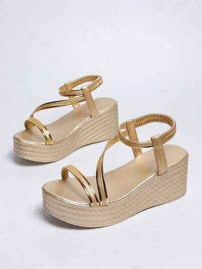 女士时尚金色拼接坡跟凉鞋，弹性套穿设计，穿着舒适便捷；轻便舒适的厚底；纹理皮革鞋面，尽显精致高端气质；适合夏季通勤和休闲穿着。