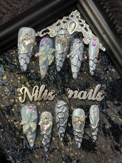 10片装美甲贴片套装，包括尖头亚克力美甲贴片、浅蓝色美甲贴片、浅蓝色猫眼美甲贴片、蓝色法式美甲贴片、冰蓝色与浅蓝色混合营造出清凉梦幻的冰雪氛围、3D立体蝴蝶贴片、金属爱心水钻贴片、水钻贴片及其他美甲配件，Y2K风格美甲套装