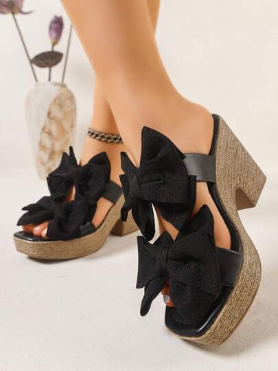 女士坡跟凉鞋。黑色超大蝴蝶结装饰，仿亚麻绳底穆勒坡跟厚底凉鞋。时尚春夏波西米亚风粗跟厚底凉鞋。适合日常穿着、派对、度假、聚会、宴会、婚礼、时装秀等场合。可搭配吊带背心、T恤、衬衫、比基尼、裙子、连衣裙、短裤等。