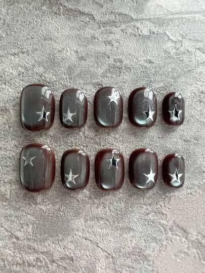 这款美甲贴片共10片，以深棕色猫眼配色为主，尽显酷炫优雅与现代时尚。指甲上点缀着银色星星，既醒目又时尚。深棕色底色搭配金属猫眼效果，再配上醒目的星星元素，使其更加独特，适合各种前卫场合。适合女士和女孩在日常出行、街头风造型和休闲聚会等各种场合佩戴，四季皆宜。手工制作，按压式美甲贴片。