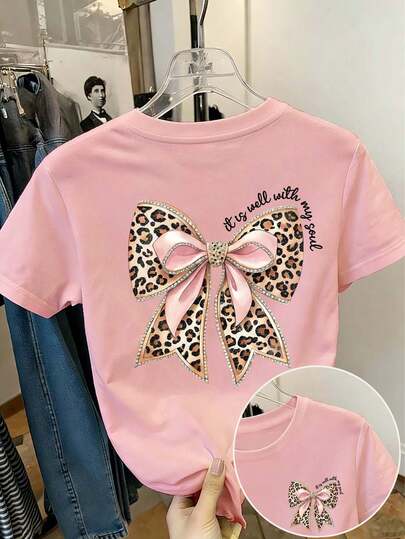 Áo thun nữ tuổi teen in họa tiết da báo và nơ, dòng chữ "It Is Well With My Soul" (Tâm Hồn Tôi Bình An), chất liệu mềm mại và thoải mái, phù hợp cho các hoạt động thể thao ngoài trời, trang phục thường ngày, phong cách đường phố và học đường, thời trang mùa xuân/hè cho các bé gái.