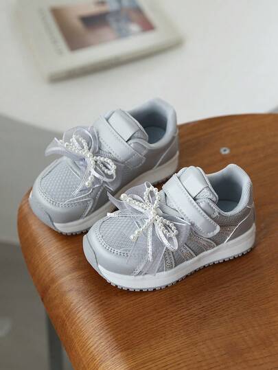 A Pair Of Shoes For Girls, Featuring A Pearl Bowknot, Leather Surface, Softness, Round Toe, Flat Sole, And Sneaker Style, Suitable For Outdoor Activities