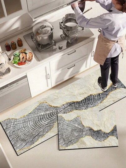 1 tấm thảm bếp bằng gel silica, với họa tiết vân gỗ sống động và những đường cong vàng óng ánh trên nền màu be và xám đậm, tạo nên một tác phẩm nghệ thuật hiện đại tự nhiên nhưng sang trọng. Tấm thảm bếp thời trang và thoải mái, có khả năng giảm chấn và chống mỏi. Bề mặt được làm bằng chất liệu vải, lớp giữa là chất liệu xốp thấm hút, và lớp dưới là chất liệu cao su, giúp dễ dàng vệ sinh và bền bỉ.
