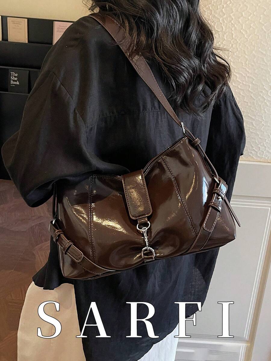 这款时尚现代的女士单肩包采用金属装饰肩带，设计独特高端。金属搭扣细节更添现代通勤风范。这款咖啡色包包配有可拆卸可调节肩带，非常适合上班族和学生使用。包包轻便实用，容量也很大。