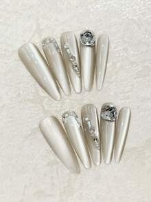 ¡Lujo a la punta de tus dedos! Juego de 10 uñas largas y puntiagudas hechas a mano en gris con destellos laterales de ojo de gato y acentos de cristal de imitación cuadrado K9. Lleno de una sensación lujosa y de alta gama. Perfecto para citas, uso diario o reuniones con amigos. Puede ser un regalo para amigos. Juego reutilizable de uñas postizas hechas a mano con una pieza de pegamento de gelatina y una lima de uñas en miniatura. - Gris Claro - Ver 14