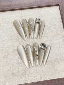 ¡Lujo a la punta de tus dedos! Juego de 10 uñas largas y puntiagudas hechas a mano en gris con destellos laterales de ojo de gato y acentos de cristal de imitación cuadrado K9. Lleno de una sensación lujosa y de alta gama. Perfecto para citas, uso diario o reuniones con amigos. Puede ser un regalo para amigos. Juego reutilizable de uñas postizas hechas a mano con una pieza de pegamento de gelatina y una lima de uñas en miniatura. - Gris Claro - Ver 4