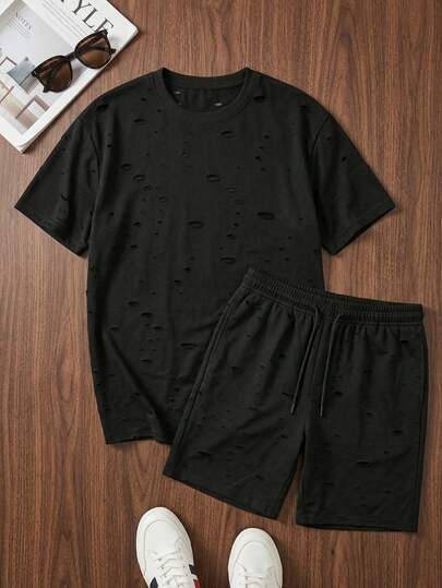Bộ đồ nam mùa hè màu trơn, chất liệu vải bạc màu, kiểu dáng thường ngày gồm quần short và áo thun ngắn tay màu đen.