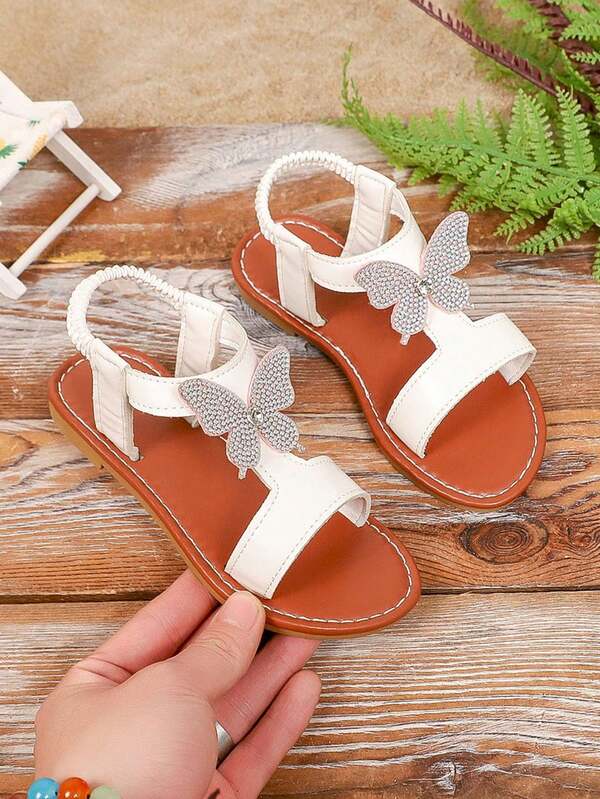 2026新款亮白色蝴蝶装饰女童绑带平底凉鞋，纯色防滑橡胶软底圆头PU儿童露趾休闲鞋，适合3-15岁女孩，适合日常、上学、演出、散步、旅行、派对、春夏穿着。