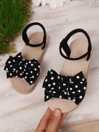 1 đôi dép xăng đan nơ đen cho bé gái, đế EVA mềm phối màu chấm bi trắng, kiểu xỏ chân, hở mũi, phù hợp cho bé gái từ 3-15 tuổi, dùng hàng ngày, đi du lịch, dự tiệc, mẫu mới Xuân/Hè 2026.
