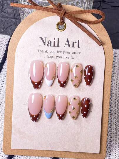 10片手工制作的杏仁形假指甲，饰以棕色波点、蓝白法式图案和钢珠点缀。指甲上镶嵌手工粘贴的金色钢珠和白色水钻，并手绘棕白波点和蓝白法式图案。优雅浪漫的简约美甲，尽显高端性感与轻盈奢华。适合日常佩戴、约会、音乐会和轻商务场合。是送给女性和女孩的理想礼物。