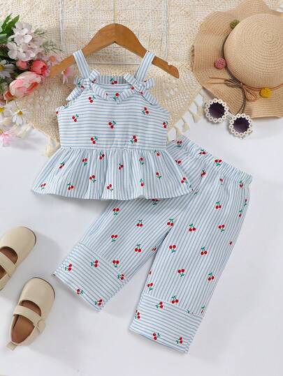 Bộ đồ 2 món thời trang tối giản cho bé gái, màu xanh dương và trắng kẻ sọc, họa tiết quả anh đào, trang trí nơ, gồm áo hai dây và quần dài.