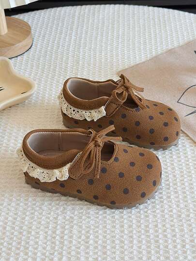 这款女童鞋采用棕色波点面料，搭配同色系双扣设计，展现活泼俏皮的风格。鞋底设计舒适贴合。