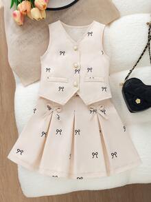 Este es un conjunto de ropa elegante y exquisito para niñas, con un color principal blanco crema, estilo chaleco sin mangas, cuello en V, combinado con una falda corta plisada, adornado con un estampado de pequeños lazos negros en todo el conjunto, el patrón de lazos negros añade un toque de encanto infantil, adecuado para actividades escolares, reuniones familiares o ocasiones formales. - Beis - Ver 3