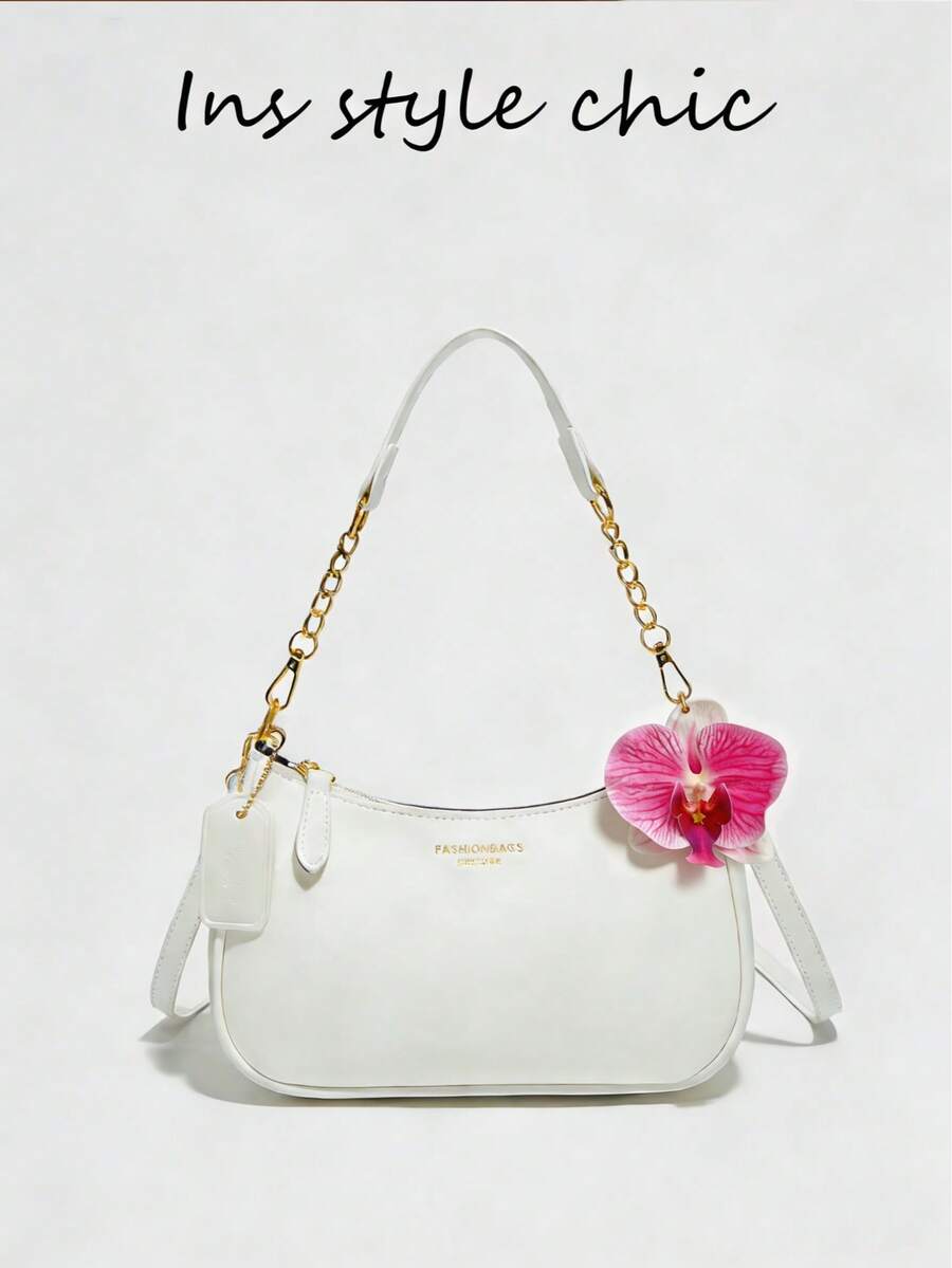 这是一款白色女士单肩包，采用PU材质制成。它是一款纯白色女士手提包，饰有红色花朵吊坠和字母装饰。这款包采用顺滑的拉链设计，配有链条手柄和可调节长肩带，方便您肩背、斜挎或手提。 - 白色 - 查看 1