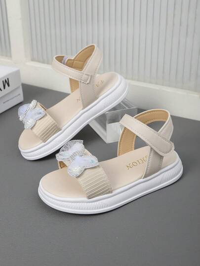 2026新款象牙色加大码女童厚底运动凉鞋，纯色面料，闪亮水钻和珍珠蝴蝶结装饰，可调节PU鞋带，露趾软底防滑时尚公主沙滩凉鞋，适合3-12岁女孩日常、海滩、学校、派对、春夏穿着。