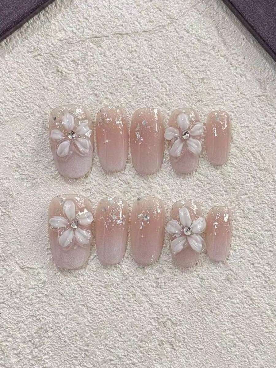 10片装，手工3D立体花朵椭圆形美甲贴纸，裸粉色渐变闪粉可重复使用美甲贴，适合婚礼、新娘、约会、派对和日常佩戴。这款精致的裸粉色渐变美甲贴纸饰有3D立体花朵和细闪水晶，营造出空灵飘逸的效果。中等长度的椭圆形指甲形状修饰手型，适合婚礼、约会等各种场合。美甲贴纸可重复使用，让您轻松打造精致美甲造型。按压式美甲贴。 - 粉色 - 查看 1
