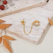 一只耳环由一条流苏链连接一个镶嵌闪亮玻璃水钻的耳钉组成，适合嘻哈、日常佩戴、音乐节和朋克风格。 - 金色 - 查看 4