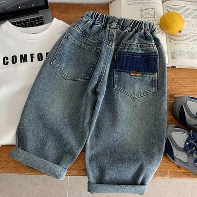 Quần jeans rách dáng rộng thời trang cho bé trai mùa thu 2026, kiểu quần ống loe rộng rãi.