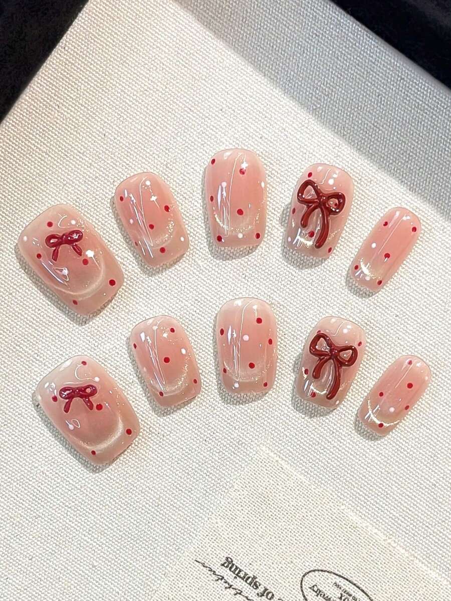 Conjunto de 10 unhas postiças quadradas feitas à mão com laço tridimensional, olho de gato vermelho com bolinhas e francesinha. Ideal para mulheres e meninas usarem no dia a dia, em festas e encontros. Acompanha cola em gel e tiras de polimento como brinde para quem gosta de unhas postiças.