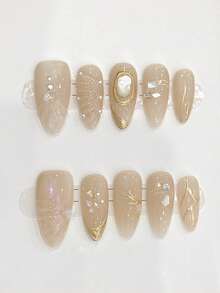 10片纯手工制作的中号杏仁形美甲贴片，以杏色为底，饰以金线、珍珠母贝小钻以及立体贝壳图案，点缀着小珍珠和小钻，呈现出精致低调的优雅气质。温柔优雅的可爱美甲，适合女士和女孩在春夏秋冬的各种节日、派对和日常生活中使用。 - 杏色 - 查看 1