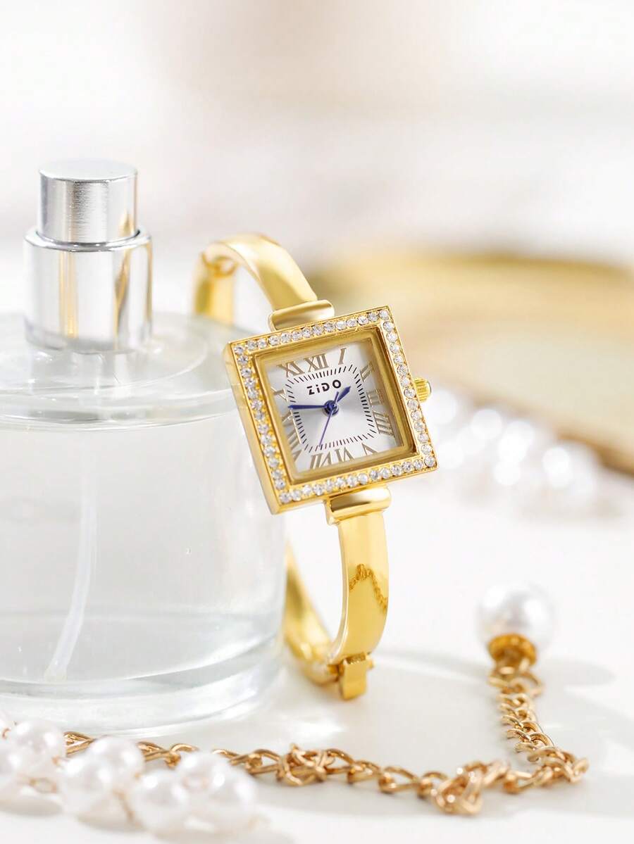 这款奢华优雅的金色女士石英腕表，采用方形表盘，镶嵌钻石表圈和经典罗马数字时标，镀金合金表壳搭配手镯式设计，简约奢华的风格，适合休闲、通勤以及搭配传统中东长袍。
