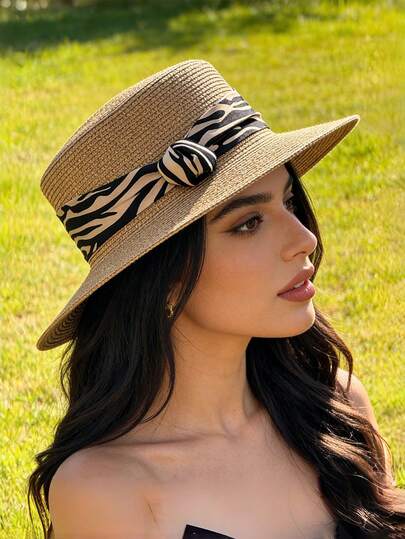 1顶优雅的宽檐斑马纹草帽，适合春夏佩戴，适用于户外活动、海滩、旅行和度假。它具有防晒、透气、吸汗、百搭和轻便的设计等特点。