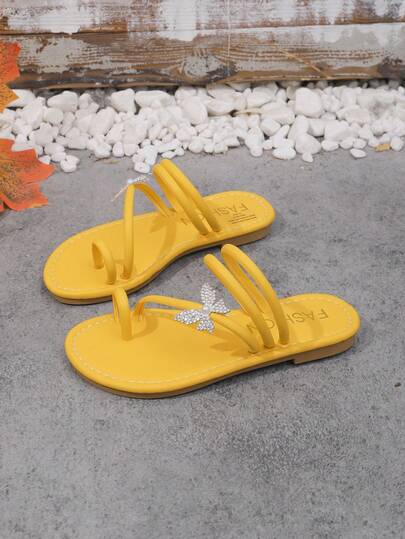 1双黄色女童时尚拖鞋，纯色柔软PU材质，人字形绑带+闪亮水钻蝴蝶装饰，圆头软底防滑，时尚优雅可爱罗马沙滩凉鞋，适合日常休闲、海滩、度假穿着，春夏新品