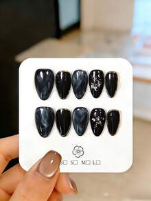 10片手工制作的杏仁形美甲贴片。这款黑色美甲贴片采用白色渐变效果，并以金色镜面粉勾勒轮廓，点缀闪亮凝胶涂层，闪耀夺目。作为实用的美甲用品和配件，它们可重复使用，易于粘贴和快速卸除。适合女性和女孩，是派对、婚礼、日常佩戴和DIY美甲的理想之选。内含工具包。手工美甲贴纸、假指甲、美甲用品。 - 黑色 - 查看 11