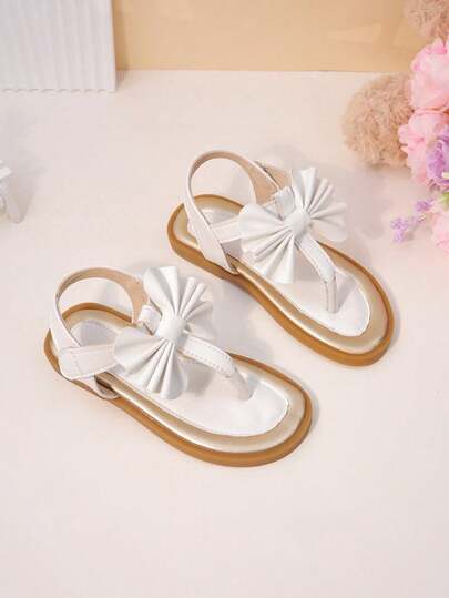 1双女童凉鞋，采用乳白色3D蝴蝶结装饰，柔软PU材质，防滑耐穿，带趾夹和魔术贴设计，平底款式，清新甜美，适合海滩度假/夏季郊游。