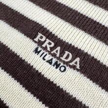 Prada Striped Embroidered Crew Neck Sweater, Custom-Knitted Mercerized Wool Blend Fabric, Soft, Delicate, Comfortable Against The Skin. The Creamy Hue And Warm Brown Tones Intertwine In The Knit Texture, Creating A Design Tension Between Movement And Stillness. The Iconic Prada Embroidery, A Subtle Yet Powerful Logo Hidden Among The Stripes, Flows In The Sunlight, The Logo Appearing And Disappearing In The Light And Shadow. The Design Is Seamlessly Integrated, Achieving The Ultimate In Aesthetics. Using Stripes As The Brush And Knitting As The Ink, A New Chapter Of Fashion Is Woven. Imported Machine Embroidery Technology, Using An Advanced Computer Control System And Precision Mechanical Parts, Achieves High Precision In Prada Embroidery, Resulting In Smooth And Delicate Lines. - 25341-B30 - Xem 5