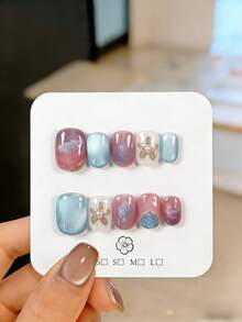 10片手工制作的椭圆形假指甲，饰以紫色渐变图案、金色镜面粉花朵纹样和蓝色猫眼效果。这些可爱的假指甲可重复使用，易于佩戴和卸除，非常适合派对、婚礼和日常佩戴。套装包含美甲工具，是送给女性和女孩的绝佳礼物。 - 彩色 - 查看 7