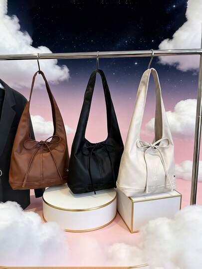 这款全新简约手提包采用蝴蝶结装饰，设计休闲又不失精致，敞口设计，并配有可调节肩带。无论是通勤、购物还是旅行，它都能轻松容纳日常必需品。这款百搭单品时尚百搭，适合各种风格和场合，用途广泛。同时，它也是馈赠亲友的绝佳礼物。