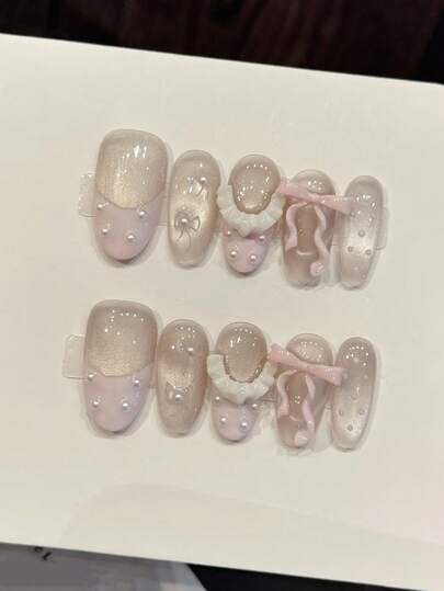 10 móng tay giả thủ công nguyên chất, kích thước trung bình, hình hạnh nhân, màu tím nhạt, kiểu dáng nữ tính nhẹ nhàng, nền hồng gradient với lớp phủ kim tuyến lấp lánh, kết hợp với nơ hồng 3D, điểm nhấn ren trắng và chi tiết chấm ngọc trai, tạo nên bộ móng tay mộng mơ và ngọt ngào cho phụ nữ và bé gái, thích hợp cho các lễ hội, tiệc tùng và sử dụng hàng ngày vào mùa xuân, hè, thu, đông.