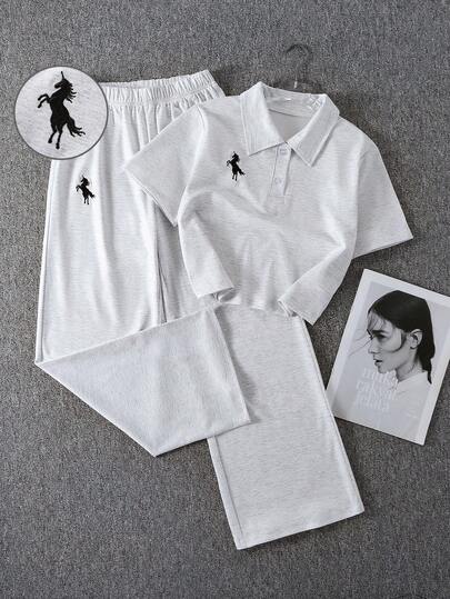 Bộ 2 món cho bé gái, gồm áo croptop cổ polo và quần ống rộng dệt kim thêu họa tiết, thích hợp cho mùa hè.