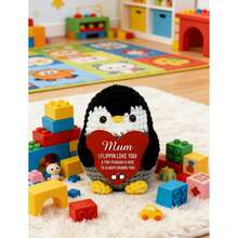 1个手工钩织圆形企鹅摆件，手捧一张鲜红色的心形卡片，卡片上印着“妈妈，我爱你”和“小企鹅永远在你身边”。设计柔软可爱，饱含温暖人心的情感，触动每一位母亲的心。 - 彩色 - 查看 6