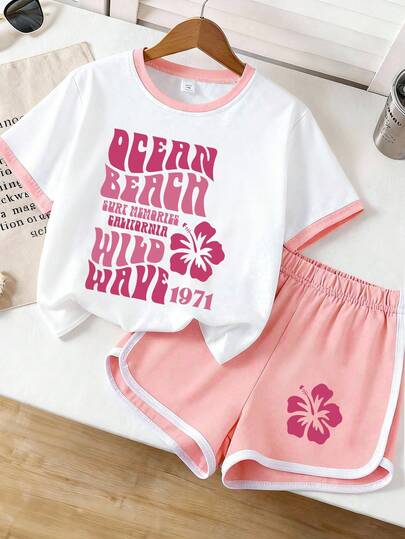 Bộ đồ thể thao mùa hè dành cho nữ, gồm áo thun ngắn tay in họa tiết hoa và họa tiết lướt sóng kiểu retro, phối cùng quần short viền tương phản, phong cách nghỉ hè.