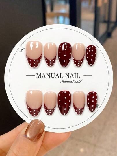 JUTI 10 Handmade Short Almond-Shaped Press-On Nail Stickers, Featuring A Classic Retro Contrast Of Nude Base With Hand-Drawn White Polka Dots And Burgundy Red French Tip Accents. They Are 100% Hand-Painted And Handcrafted, Showcasing These Elegant Romantic Sweet Nails.