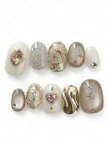 这款美甲套装包含10片指甲油，名为“金沙月心”。它巧妙地融合了闪耀的香槟色和乳白色，金色的星星和宝石细节在柔和的底色上熠熠生辉，宛如繁星点缀在金色的沙滩上。波浪状的液态金属装饰更添一丝俏皮奢华，营造出梦幻般的怀旧氛围。 - 彩色 - 查看 1