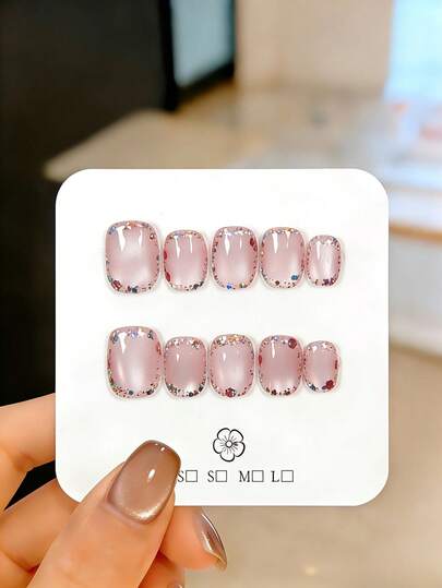 10片手工制作的樱花粉猫眼款短椭圆形假指甲，饰以混合闪粉和碎钻。这些可爱漂亮的假指甲可重复使用，易于佩戴和卸除，是优雅的美甲装饰。适合女孩和女士日常佩戴，也适合派对、婚礼和节日美甲。套装包含美甲工具，如果冻胶和指甲锉。