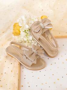 1 đôi sandal đế bằng màu vàng kim cỡ lớn dành cho bé gái, chất liệu PU mềm mại, bóng bẩy, trang trí nơ lớn, quai đeo mắt cá chân co giãn, mũi tròn, đế chống trượt thoải mái, kiểu sandal La Mã thời trang, thanh lịch, dễ thương phù hợp cho bé gái từ 3-15 tuổi, dùng hàng ngày, dự tiệc, du lịch, mùa xuân/hè 2026. - Hoa hồng vàng - Xem 6
