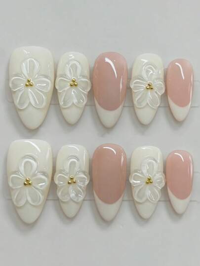 10片纯手工制作的中号杏仁形美甲贴片，法式边框采用裸粉色和奶油白色组合而成。透明立体花朵点缀其间，金色珠状花蕊更添柔美气息。这款美甲贴片优雅可爱，适合女士和女孩在春夏秋冬的各种场合，如节日、派对和日常生活中使用。