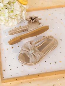 1 đôi sandal đế bằng màu vàng kim cỡ lớn dành cho bé gái, chất liệu PU mềm mại, bóng bẩy, trang trí nơ lớn, quai đeo mắt cá chân co giãn, mũi tròn, đế chống trượt thoải mái, kiểu sandal La Mã thời trang, thanh lịch, dễ thương phù hợp cho bé gái từ 3-15 tuổi, dùng hàng ngày, dự tiệc, du lịch, mùa xuân/hè 2026. - Hoa hồng vàng - Xem 7